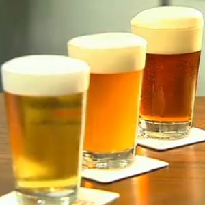 Three beers laid out on coasters lined up in a row